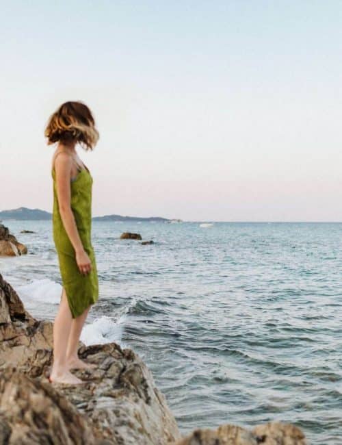 kaboompics_a-woman-in-a-green-dress-on-a-rock-by-the-sea-18067